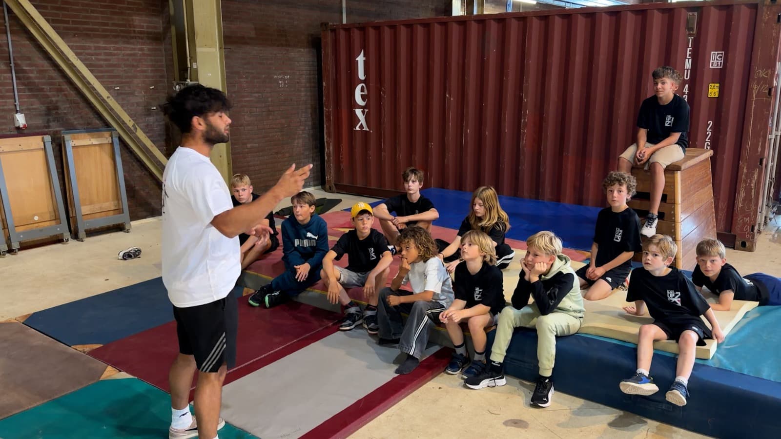 Deelnemers luisteren naar uitleg tijdens een freerunningtraining